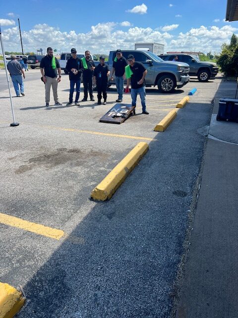 A group of people standing around in the parking lot.