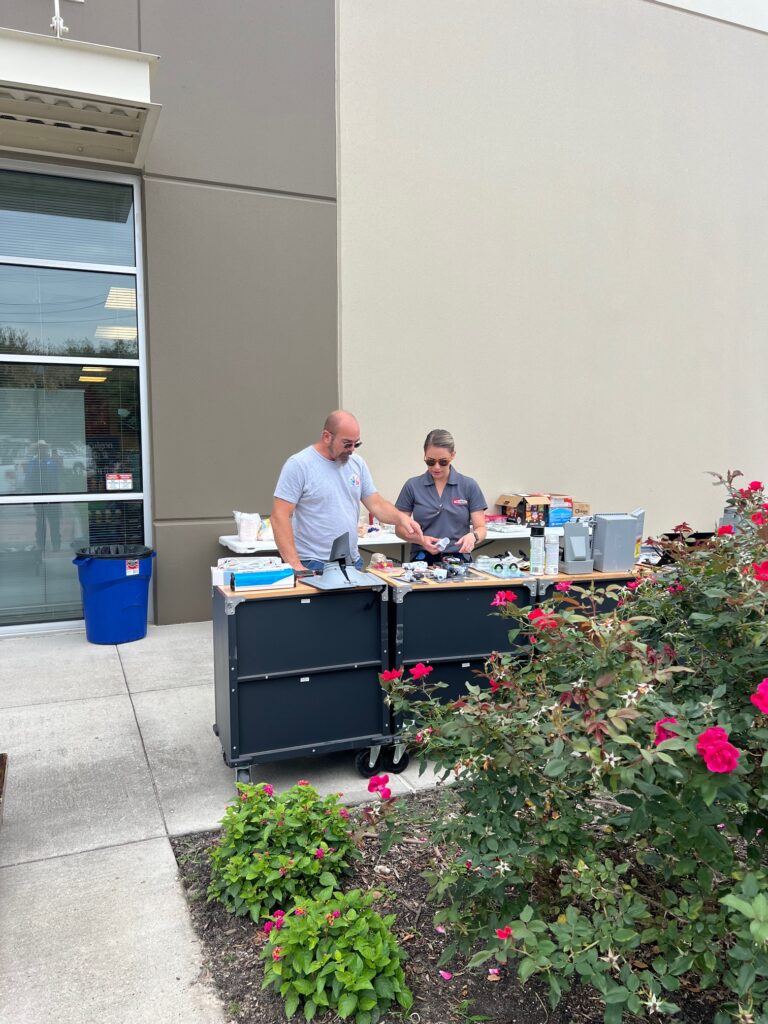 Two men standing at a table with food.