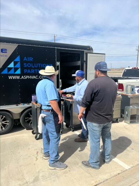 Three men standing around a trailer with air solutions.