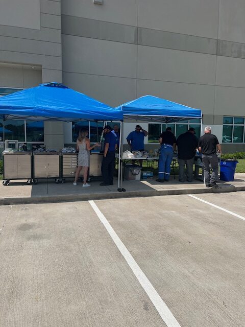 A group of people standing around an open tent.