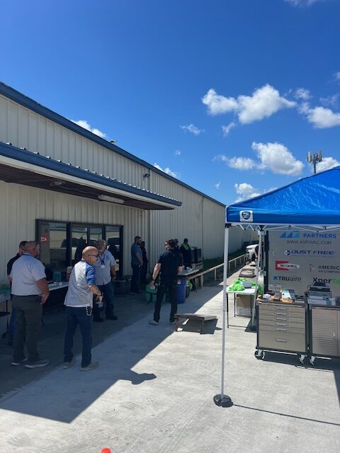 A group of people standing outside near an awning.